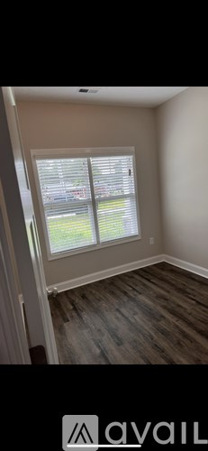 A room with a window and wooden flooring.