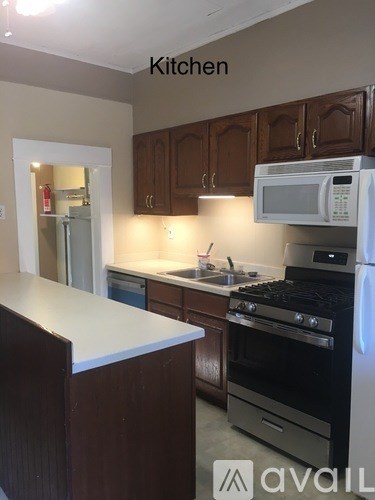 A kitchen with brown cabinets and a white counter.