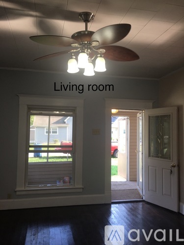 A living room with a ceiling fan and a window.