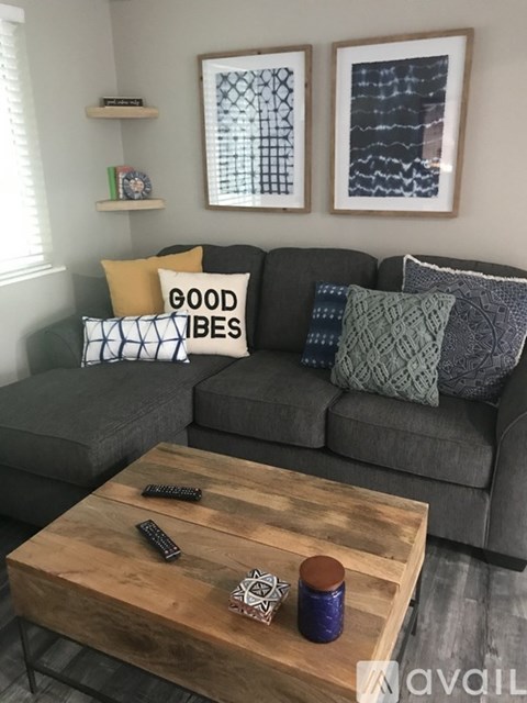 A living room with a grey couch and a wooden coffee table.