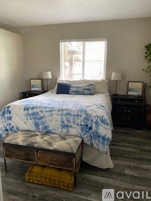 A bedroom with a bed, nightstands, and a bench.