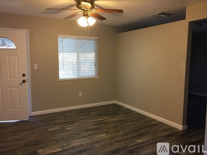 A room with a ceiling fan and a door.