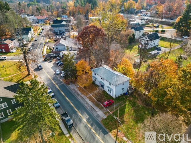 A street view of a residential area with houses and trees.