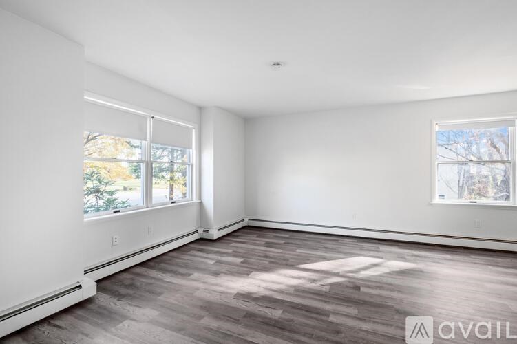 A room with a large window and a wooden floor.