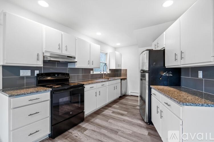 A kitchen with white cabinets and a black oven.