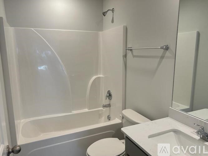A white bathroom with a toilet, sink, and bathtub.