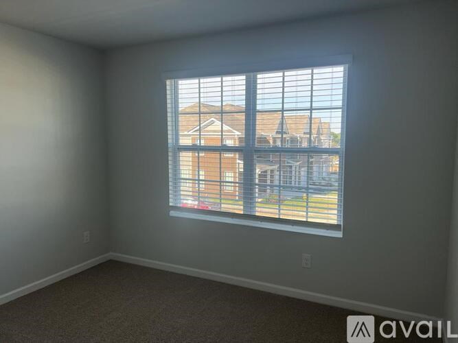 A room with a large window overlooking a residential area.