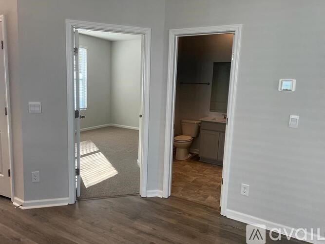 A room with a toilet and a sink is visible through an open door.