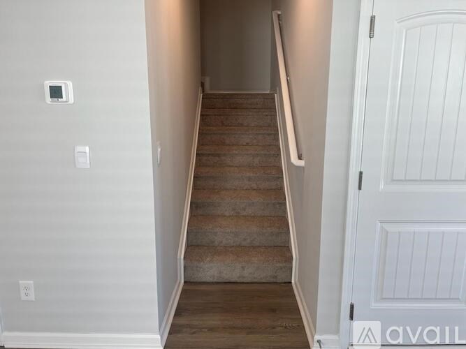 A staircase with a white door on the right side.