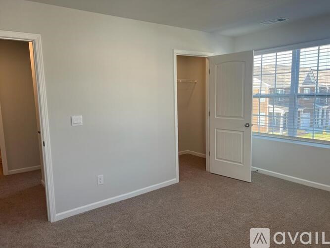 A room with two doors and a window with blinds.