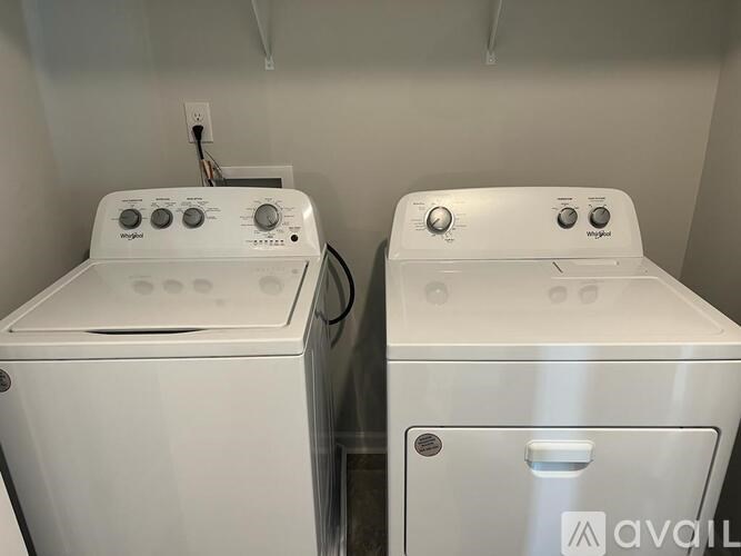 Two white front loading washing machines in a laundry room.