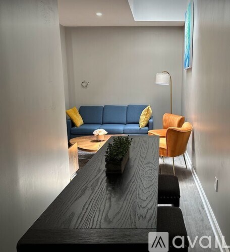 A living room with a blue couch and a wooden table.
