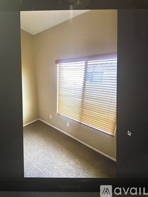 A room with a window covered by blinds.