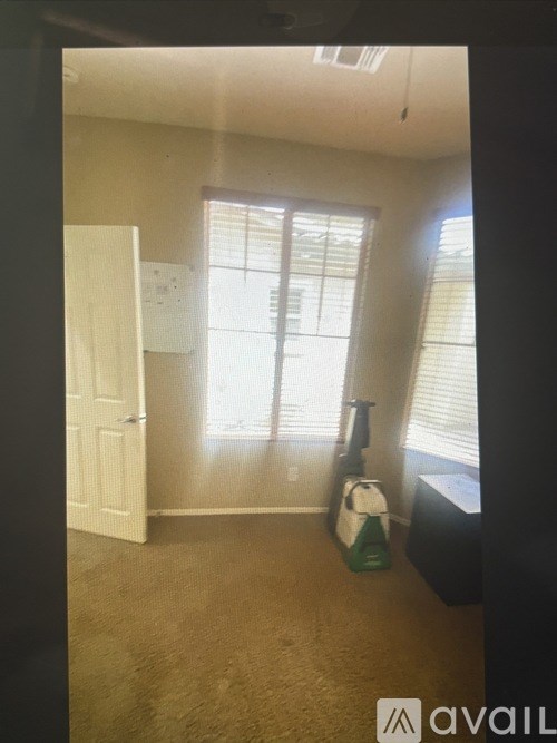 A room with a white door and a window with blinds.