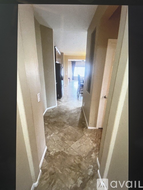 A hallway with a tiled floor and walls on either side.