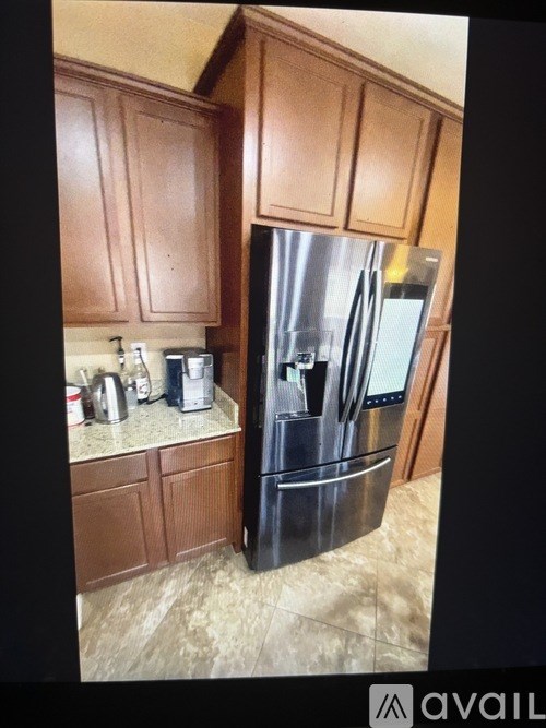 A kitchen with a black refrigerator and wooden cabinets.