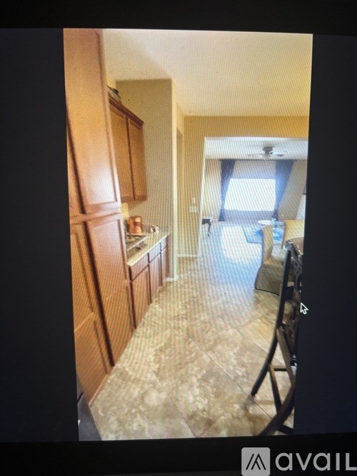 A kitchen with wooden cabinets and a tiled floor.