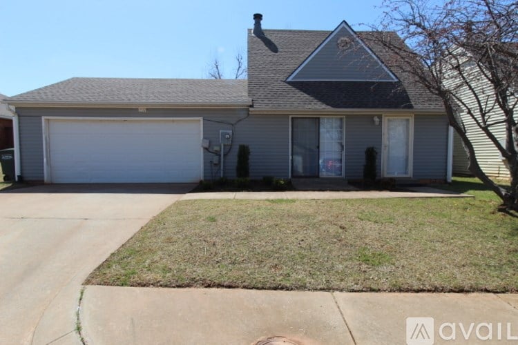 A house with a grey roof and a white garage door.