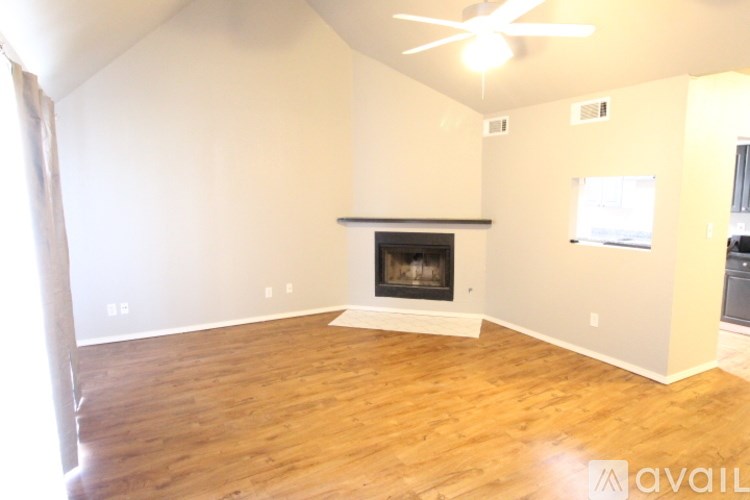 A living room with a fireplace and a ceiling fan.