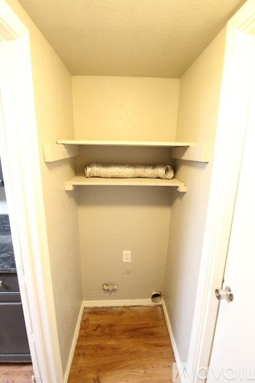 A small, empty room with a white shelf and a towel on it.