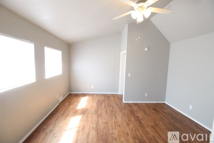 A room with wooden floors and a ceiling fan.