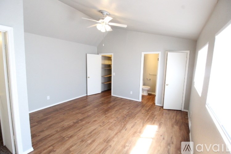 A room with a ceiling fan and wooden floors.