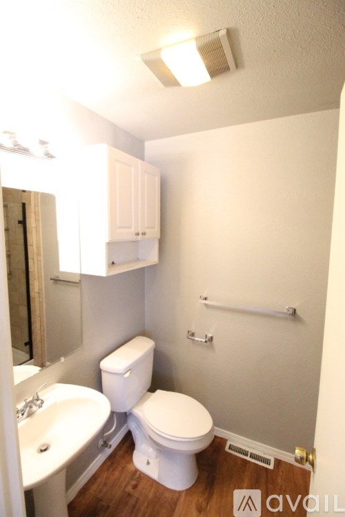 A small white toilet sits in a small bathroom.