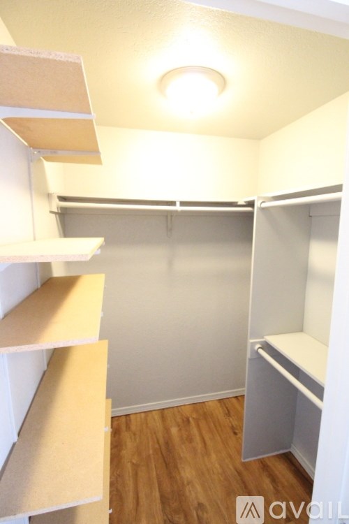 A small, empty room with a wooden floor and white walls.