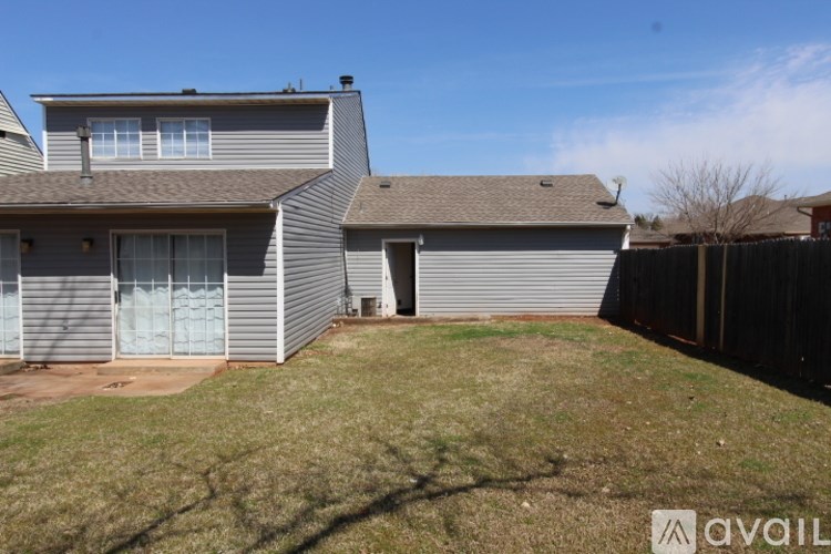 A house with a grey roof and a fence in front of it.