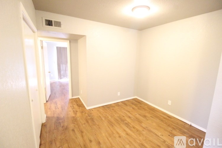A room with wooden flooring and white walls.