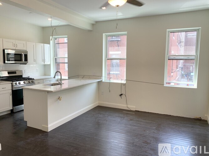 A spacious kitchen with white appliances and a large island.
