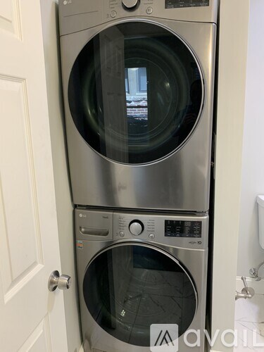 A stacked washer and dryer in a small room.