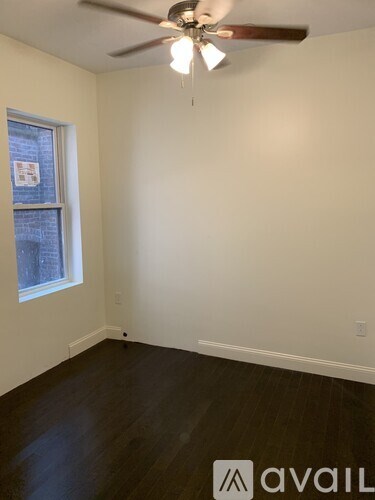 A room with a ceiling fan and a window.