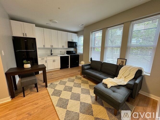 A kitchen with black appliances and white cabinets is shown.