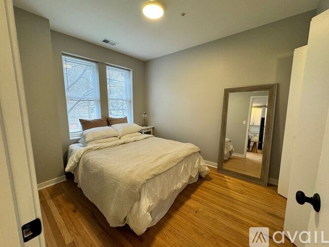 A bedroom with a large bed and a mirror on the wall.