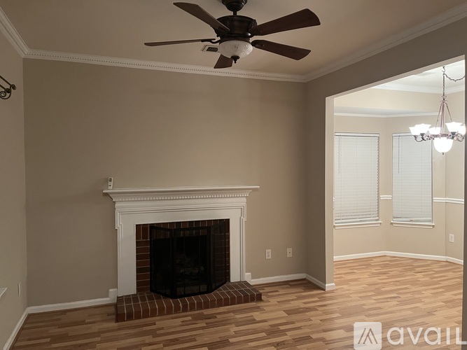 A room with a fireplace and a ceiling fan.