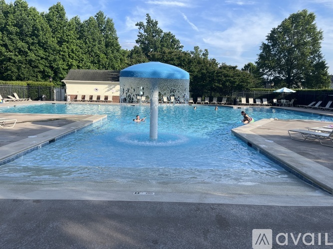 A large outdoor swimming pool with a waterfall feature in the middle.