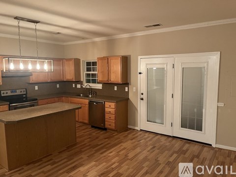 A kitchen with wooden floors and white walls.