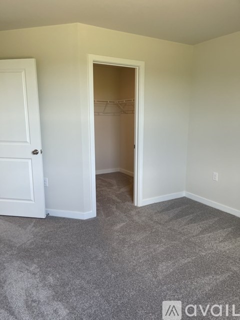 A room with a carpeted floor and a white door.