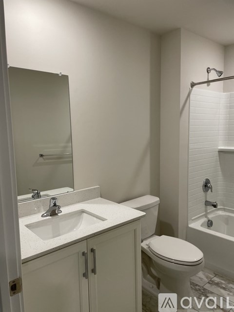 A white bathroom with a sink, toilet, and bathtub.