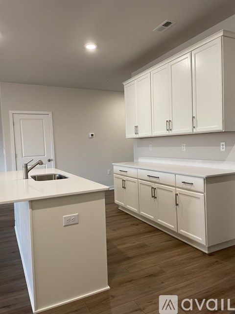 A kitchen with white cabinets and a white countertop.