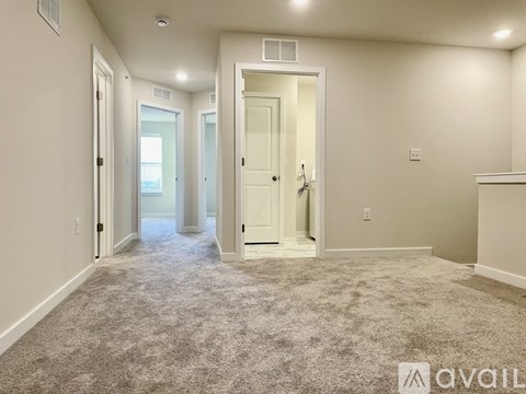 A spacious room with carpeted floor and white walls.