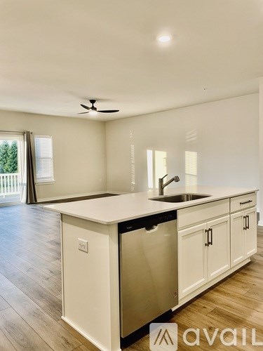 A kitchen with white cabinets and a stainless steel dishwasher.