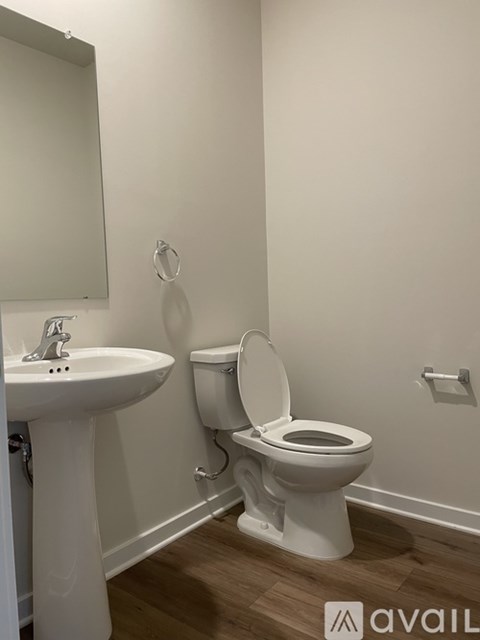 A white toilet with the seat up in a bathroom.