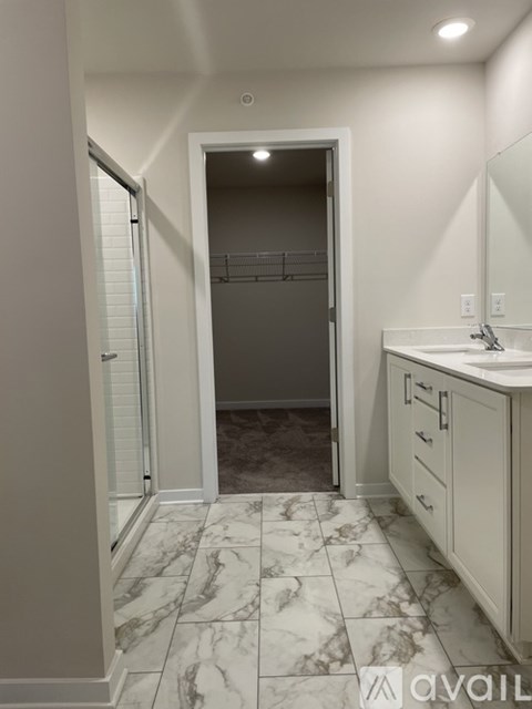 A bathroom with a marble floor and white walls.