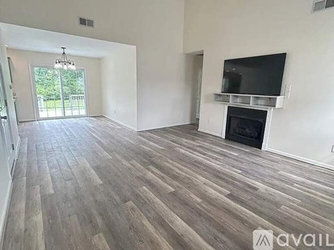 A living room with a fireplace and a television mounted above it.