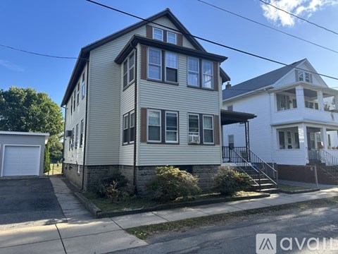 A two-story house with a garage on the left and a driveway in front.