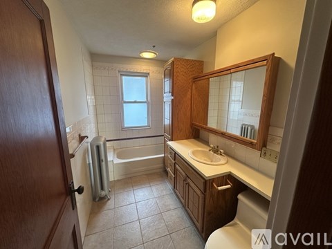 A bathroom with a toilet, sink, and bathtub.
