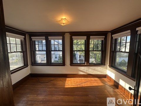 A room with wooden floors and windows overlooking a building.