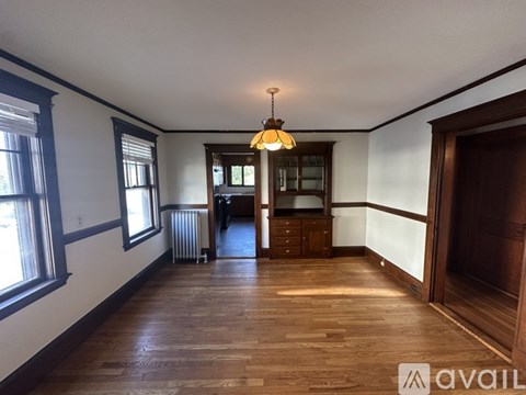 A room with wooden floors and a chandelier hanging from the ceiling.